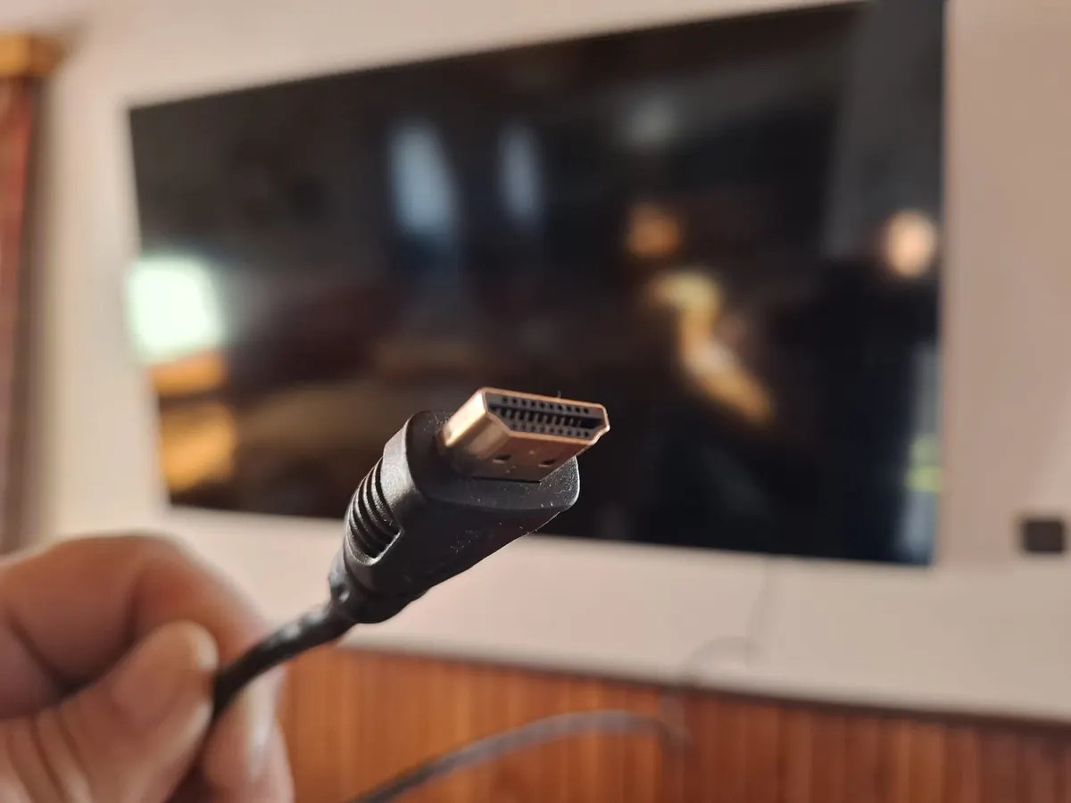 Kabel HDMI před velkou televizí