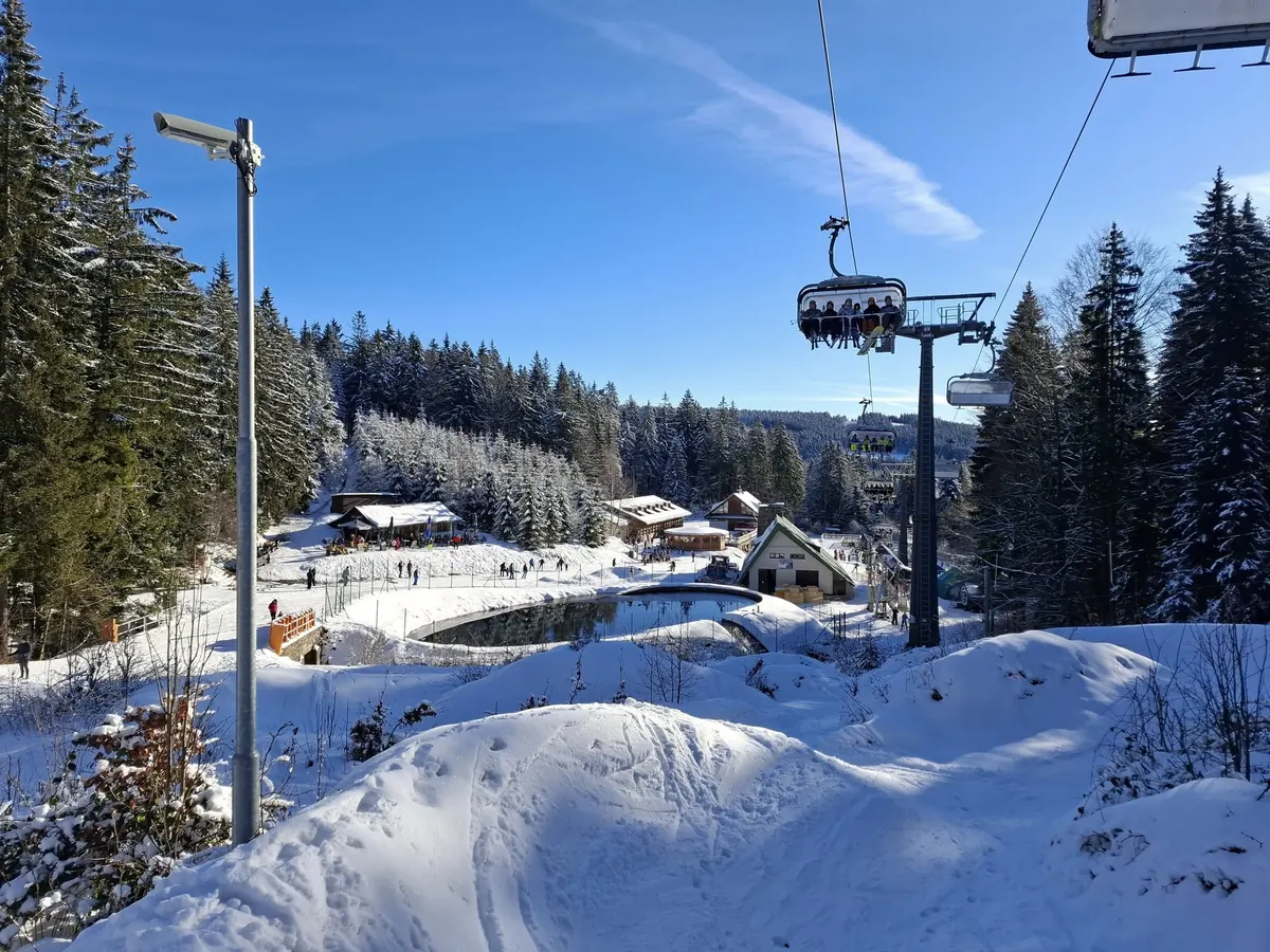 Sedačková lanovka a dolní areál se zasněženými chatami